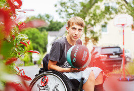Junge im Rollstuhl mit Basketball 