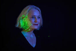 Miriam Meckel vor schwarzem Hintergrund, mit grünem Laser über dem Gesicht. Illustration zum Thema Technik